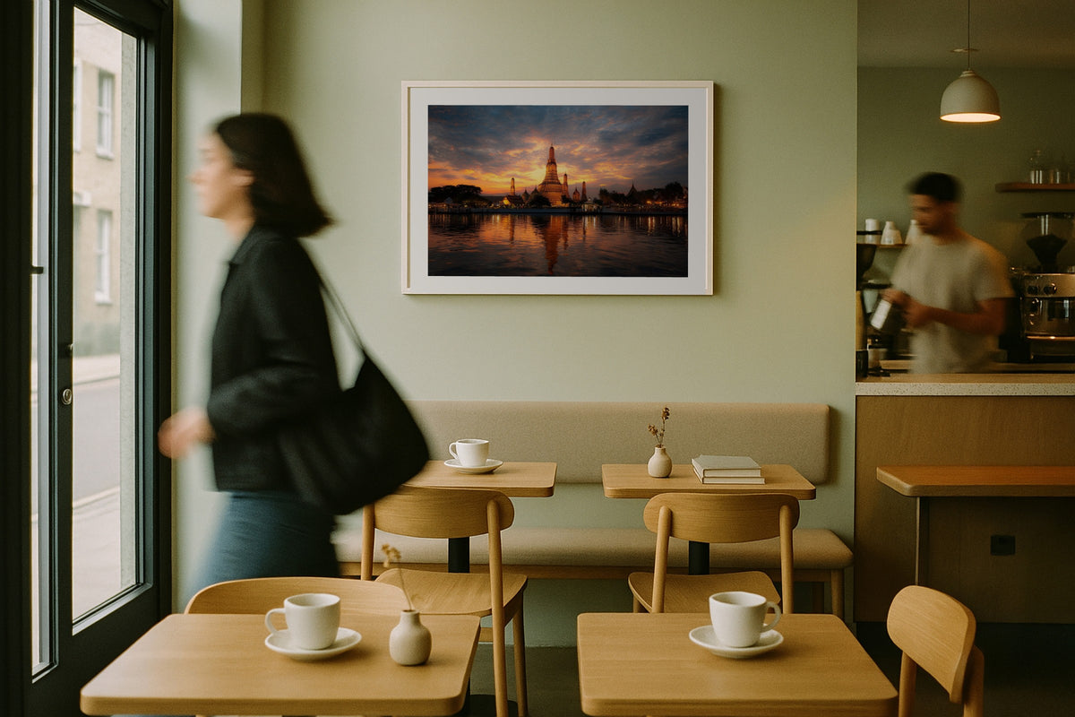 Bangkok Riverside Temple wall art print, framed with a white border, in a cafe woman walking past