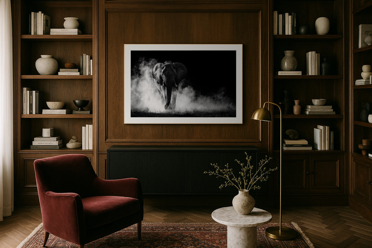 Charging Elephant wall art print, framed with a white border, in a dark wood office leather chair