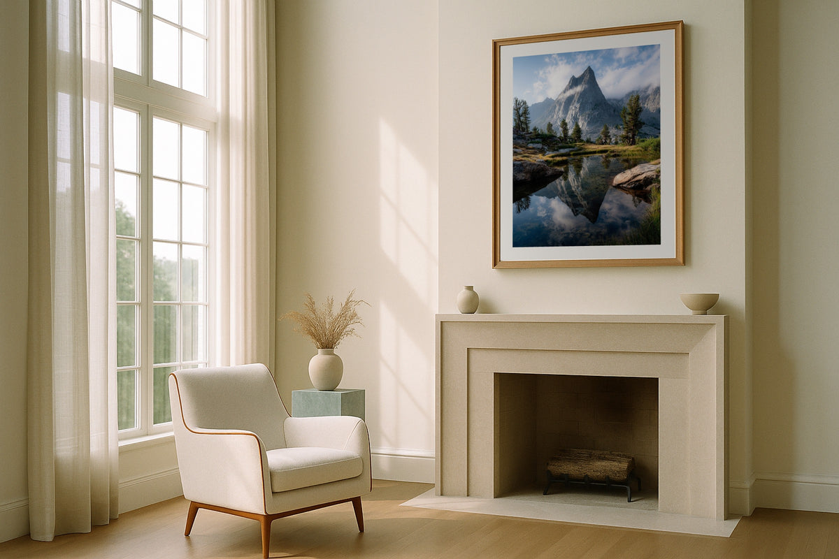 Prusik Peak wall art print, framed with a white border, in a fireplace boucle chair