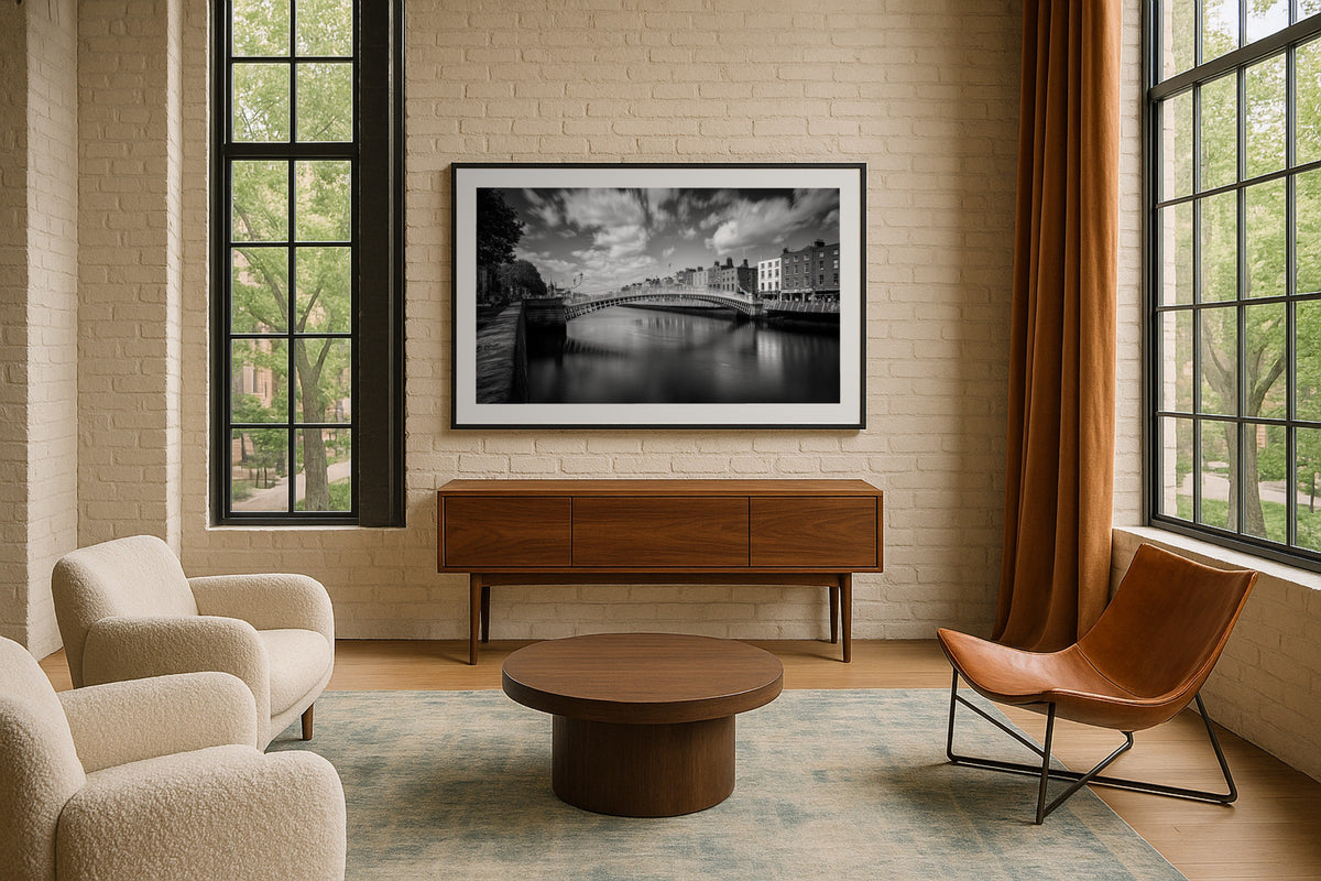 Ha’penny Bridge II wall art print, framed with a white border, in a brick loft armchairs