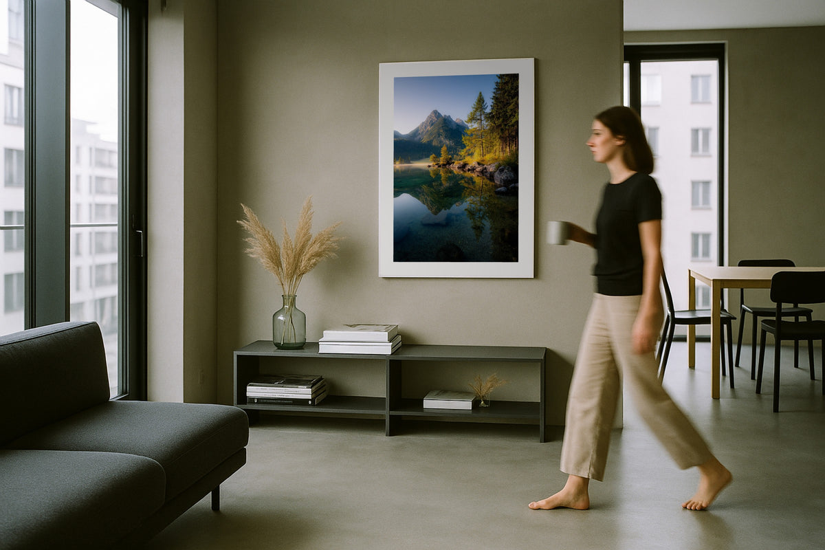 Hintersee in Autumn wall art print, framed with a white border, in a woman walking modern grey room