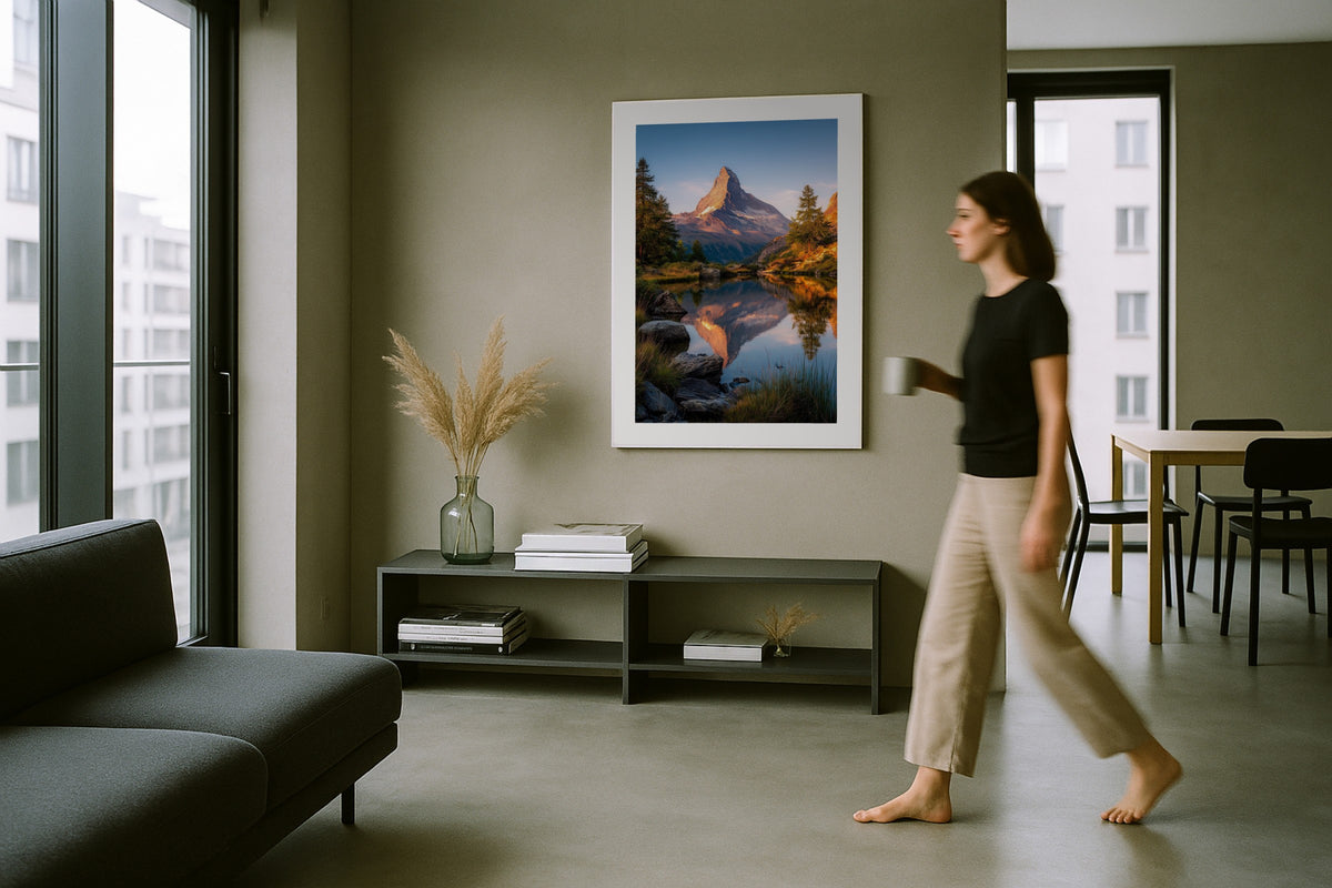 Matterhorn Reflected wall art print, framed with a white border, in a woman walking modern grey room