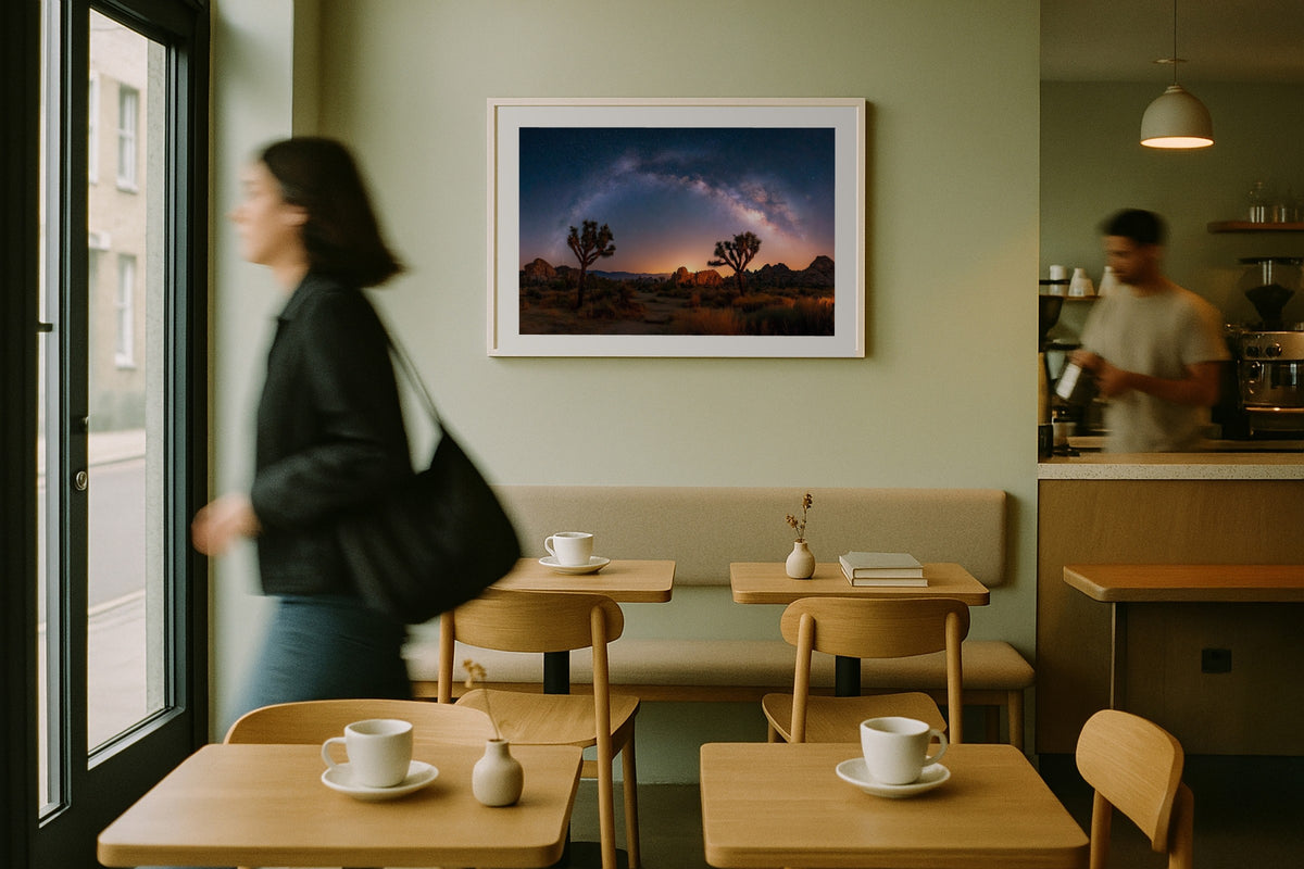 Joshua Tree Galaxy wall art print, framed with a white border, in a cafe woman walking past