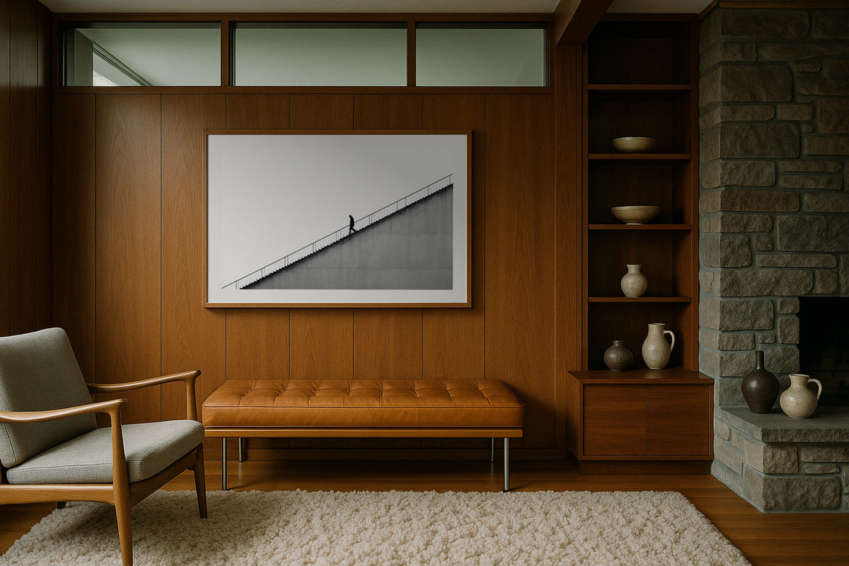 Figure on the Stairs wall art print, framed with a white border, in a midcentury stone fireplace
