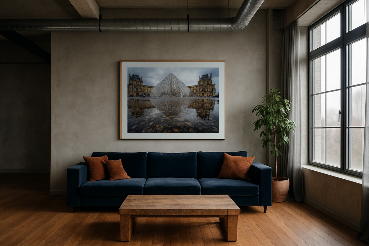 The Louvre Pyramid II wall art print, framed with a white border, in a industrial navy sofa