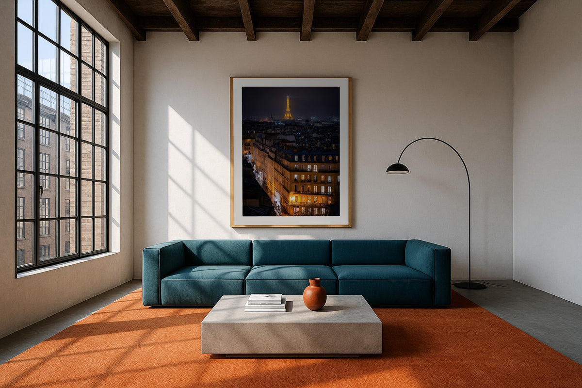 Paris Rooftops at Night wall art print, framed with a white border, in a teal sofa orange rug loft