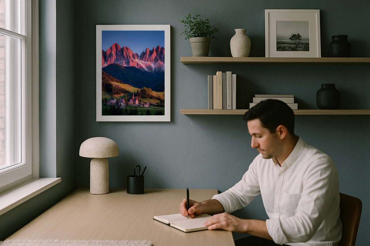 Santa Maddalena Alpenglow wall art print, framed with a white border, in a man writing blue wall
