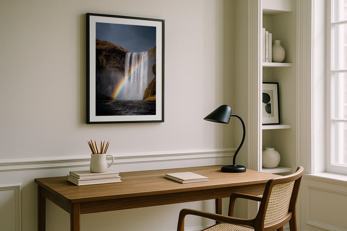 Skógafoss Rainbow wall art print, framed with a white border, in a white desk black lamp