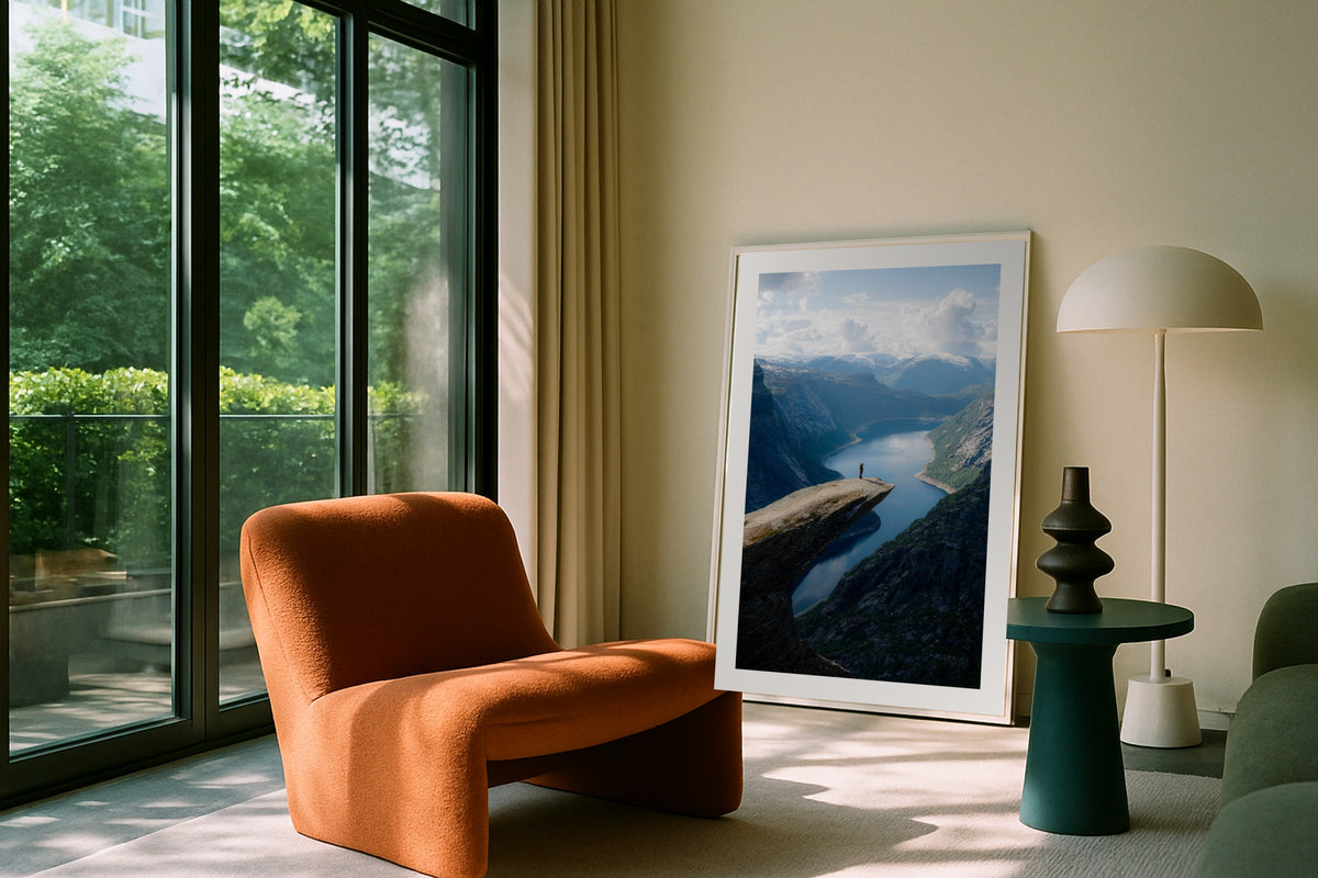 Hiker at Trolltunga wall art print, framed with a white border, in a white coastal fireplace