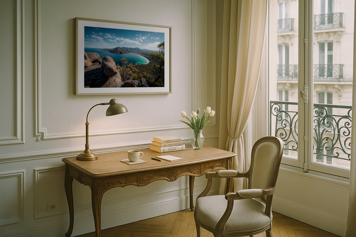 Wineglass Bay wall art print, framed with a white border, in a Paris balcony desk
